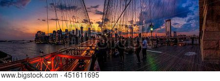 Tourist Enjoying The Twilight Skyline Over New York City From The Brooklyn Bridge As Traffic Flows F