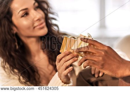 A Happy Couple Of Mulattoes Exchange Gifts With Each Other. Celebrating Joint Family Events.