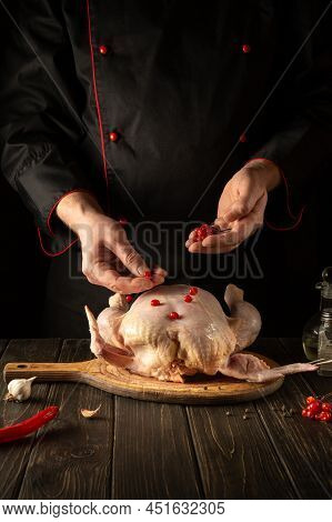 The Cook Adds Red Viburnum To The Broiler Chicken Before Roasting. Cooking National Dishes In The Ki