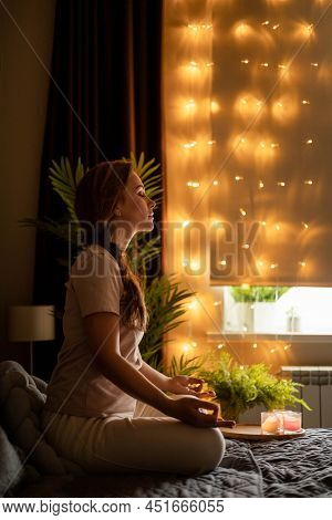 Relaxed Yoga Woman Meditation In Lotus Position With Hands Namaste On Bed At Bedroom