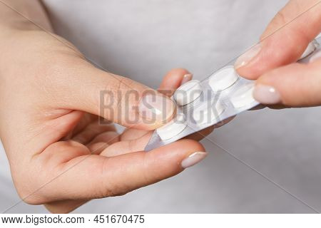 Female Hand With A Pill In Foil Packaging