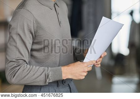 Minimal Cropped Shot Of Unrecognizable Man Holding Document And Wearing Grey In Office, Copy Space