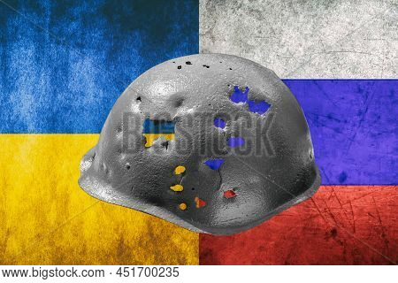 Military Helmet Pierced By Lot Of Bullets And Shrapnel On The Background Of The Ukrainian And Russia