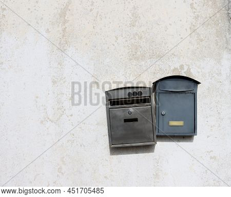 Two Metal Mailboxes Hang On A Light, Dirty Wall. Old Mailboxes.