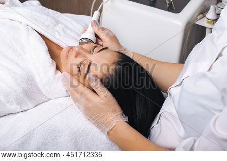 Caucasian Woman Lying On A Table Getting Facial Cavitation Treatment In The Spa Salon. Healthy Lifes