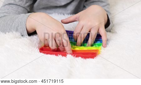 Little Boys Hands Are Playing An Educational Game. Colorful Antistress Sensory Toy Fidget Push Pop I