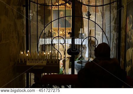 San Pietro, Italy - Dicembre, 26, 2021 A Silhouette Of A Person Praying In A Church In The Shade Aga