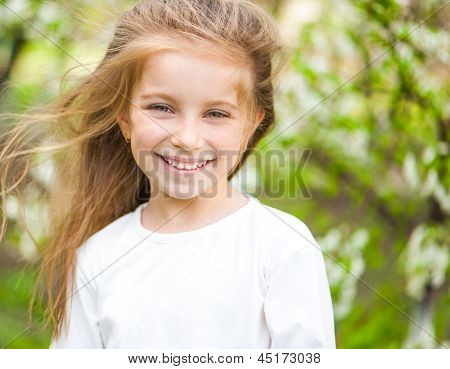 adorabile bambina sul prato nel giorno solare