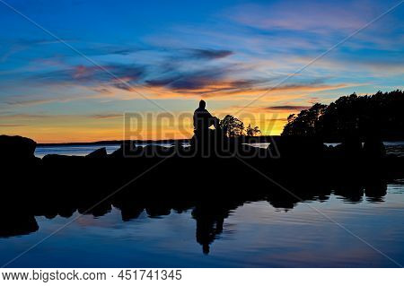 Man Sitting Overlooking Sunset Over Lake Vattern