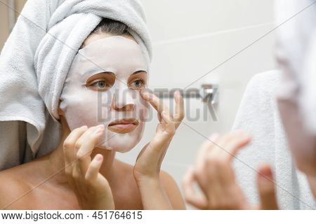 Woman In Bathroom Is Applying Facial Sheet Mask