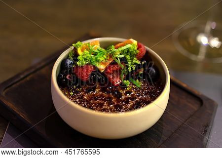 Creme Brulee With Caramelized Sugar Custard Decorated With Berries And Mint