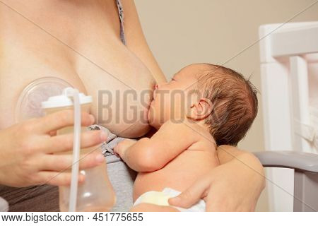 Breast Pump Close-up And Mother Breastfeed Baby In Nursery