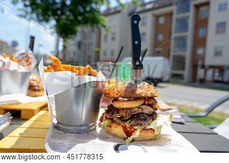 Eating Street Food Burger On The Street With Sweet Potato Fries