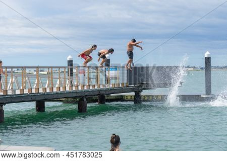 Tauranga New Zealand March 26 2022;boys Enjoy Jumping Of Pier And Diving Platform On City Waterfront