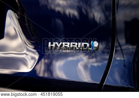 Brecht, Belgium - Februari 5 2022: A Hybrid Logo On A Blue Car Body Showing That The Vehicle Has Hyb
