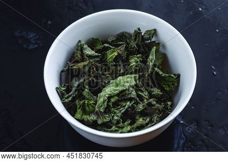 Dried Leaves Mint Or Melisa Or Basil Or Other Herbs In Plate On Black Background
