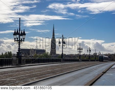 Stone Bridge On The Garonne River In Bordeaux With St Michel Cathedral, France.