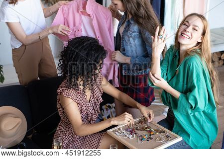 Young Women At Swap Party. Trying On Casual Clothes, Shoes, Hats, Bags, Jewellery. Idea Of Exchange 