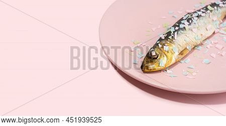 Fish Covered Microplastic On A Pink Plate. Impact Of Micro Plastic On The Food Chain. The Idea Of Mi