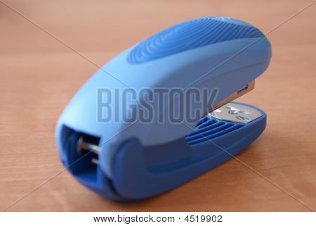 Blue Stapler On The Wooden Table