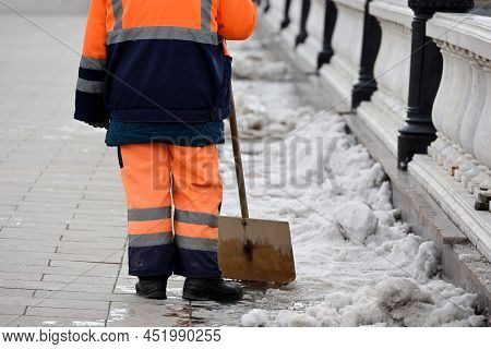 Snow Removal In Spring City. Worker In Uniform With Shovel, Street Cleaning
