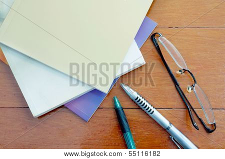 Book Pen And Glasses On Red Wood Table