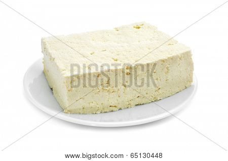 a block of tofu in a plate on a white background