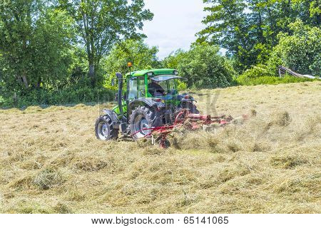 Tractor In Meadow Making Hay
