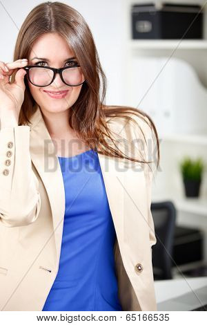 woman wearing glasses posing in office dress
