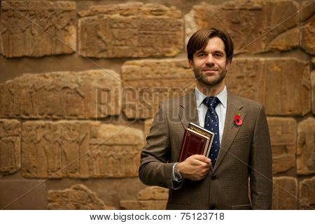 Smiling Bearded Schoolteacher In Museum Carrying Books