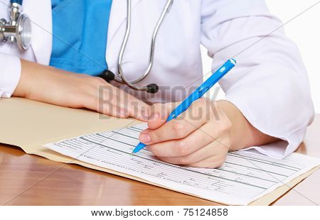 Young female doctor at desk isolated.