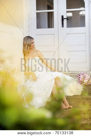 Blonde bride by old house