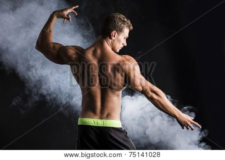 Handsome Shirtless Bodybuilder Striking A Pose, Back View