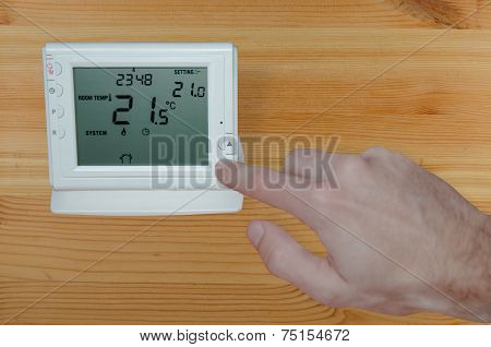 Adjusting The Temperature With Hand To A Wireless Thermostat