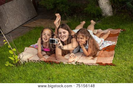 Mother And Two Daughters Making Photos Of Themselves At Park
