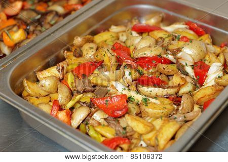 Steel container with potato wedges and vegetables