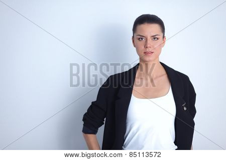 A young woman standing, isolated on graybackground