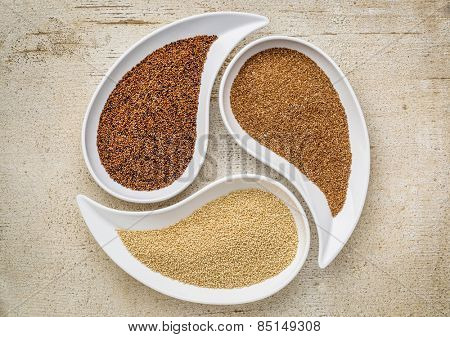 three tiny gluten free grains - kaniwa, amaranth and teff on teardrop shaped bowls against white painted rustic wood