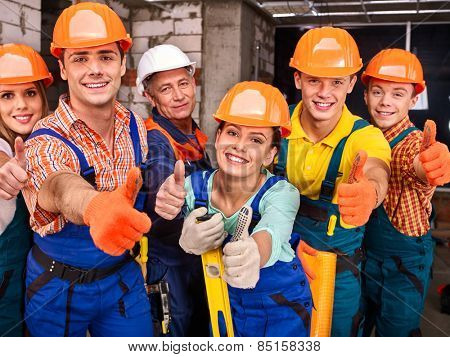 Happy group people in builder uniform thumb up.
