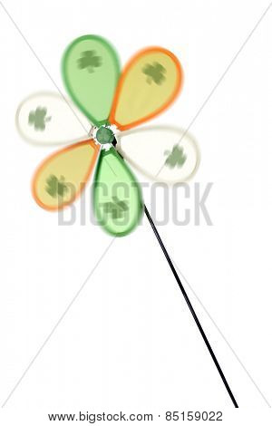 A spinning green, orange and white Irish pinwheel with a shamrock on each blade.  Isolated on white.