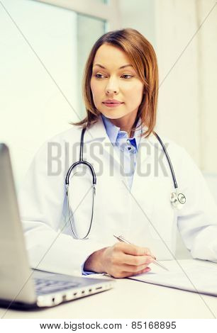 medicine and healthcare concept - busy doctor with laptop computer
