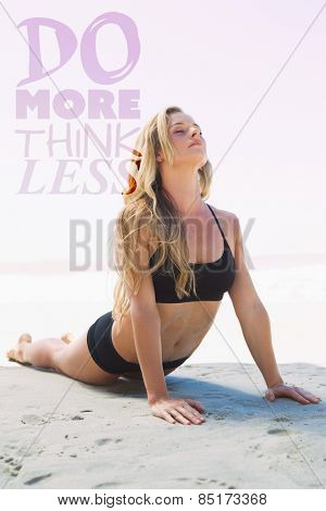 Fit blonde in cobra pose on the beach against do more think less