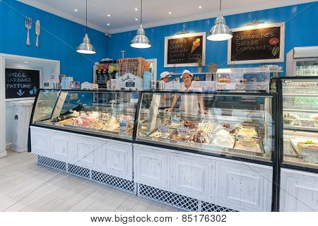 DUBROVNIK, CROATIA - MAY 26, 2014: Smiling young waitress at Gossip ice cream shop on main street Stradun. It is one of the best ice cream place in town popular among tourists.