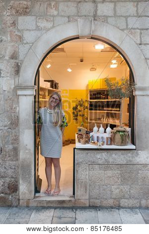 DUBROVNIK, CROATIA - MAY 28, 2014: Sales woman standing at  entrance to souvenir shop on Stradun, main street in Dubrovnik.