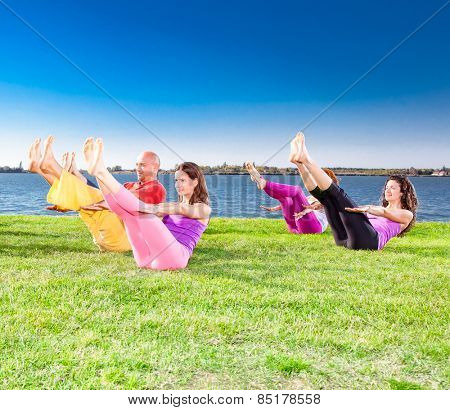 Young people practice Yoga asana on lakeside. Yoga concept.