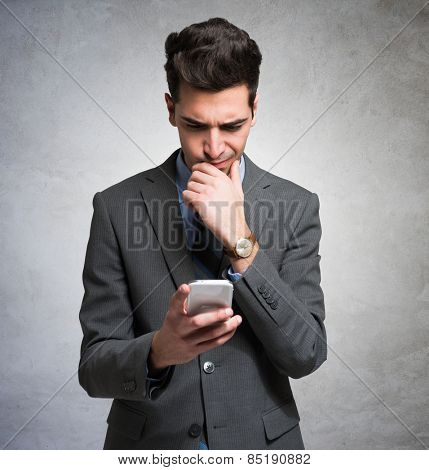 Puzzled man using his mobile phone