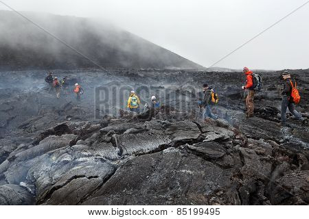 Tourists Hiking On Hot And Steaming Lava Field Eruption Tolbachik Volcano On Kamchatka. Russia
