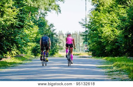 Young pair of professional cyclists riding on the road