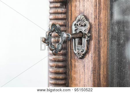 Vintage keyhole with key on vintage wooden cabinet with white background