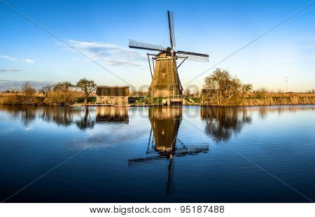 Windmill Reflecting In Water In Netherlands